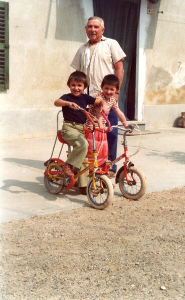 Bambini sul triciclo in cortile